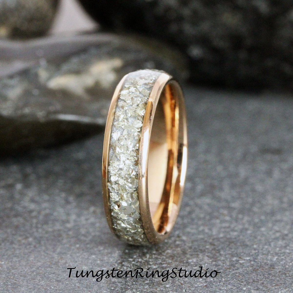 May include: A rose gold tungsten carbide ring with a band of white crushed diamonds. The ring is a simple design with a polished finish.