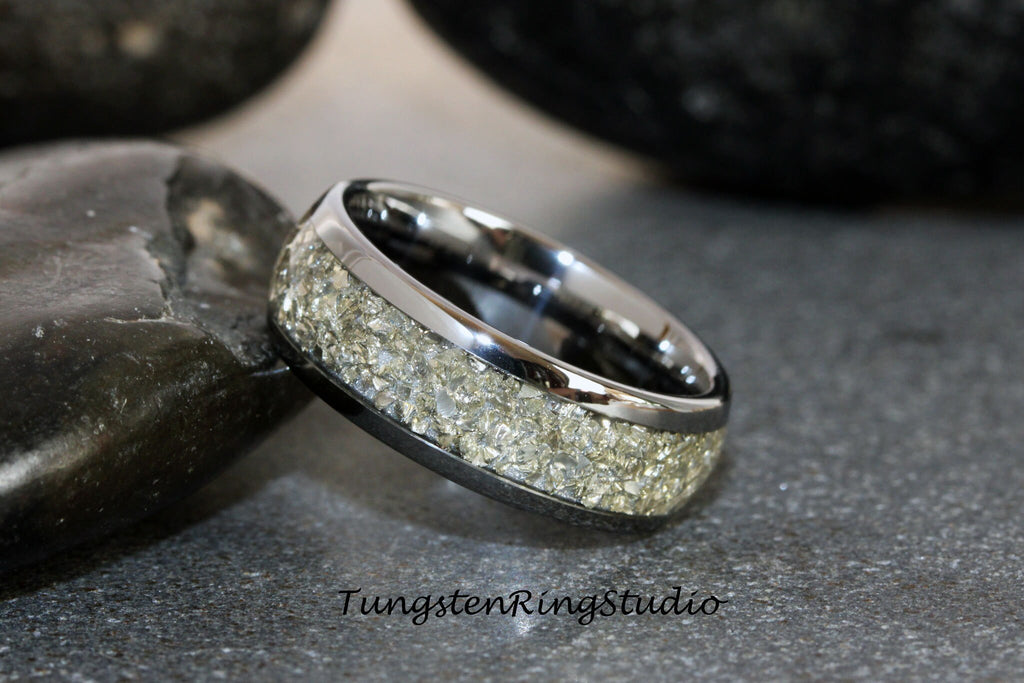 May include: A silver tungsten carbide ring with a band of embedded light gray stones.