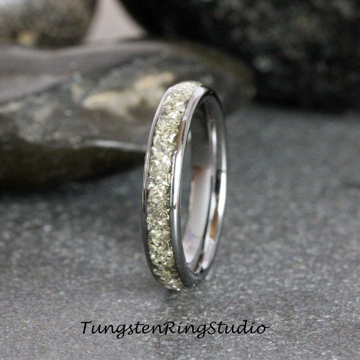 May include: A silver tungsten ring with a band of small, clear stones.