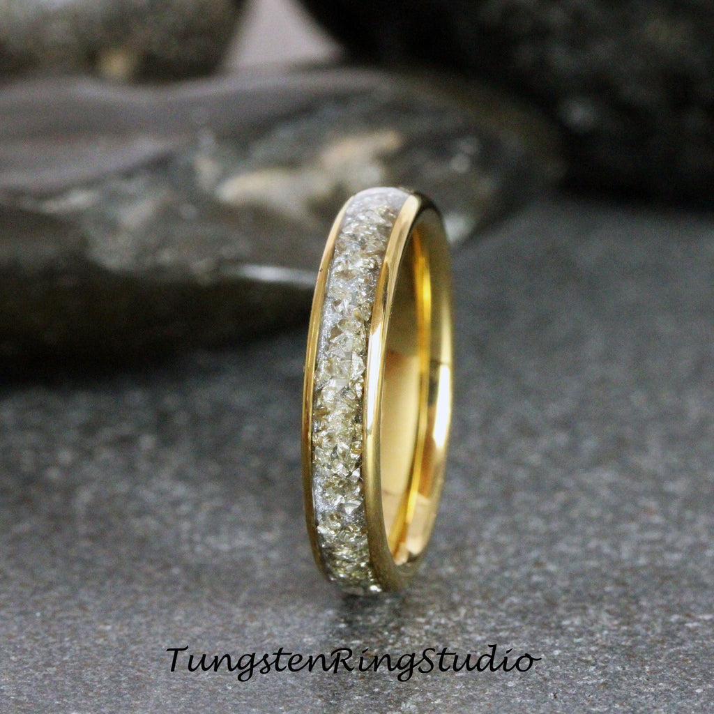 May include: A gold tungsten carbide ring with a band of small, clear diamonds.