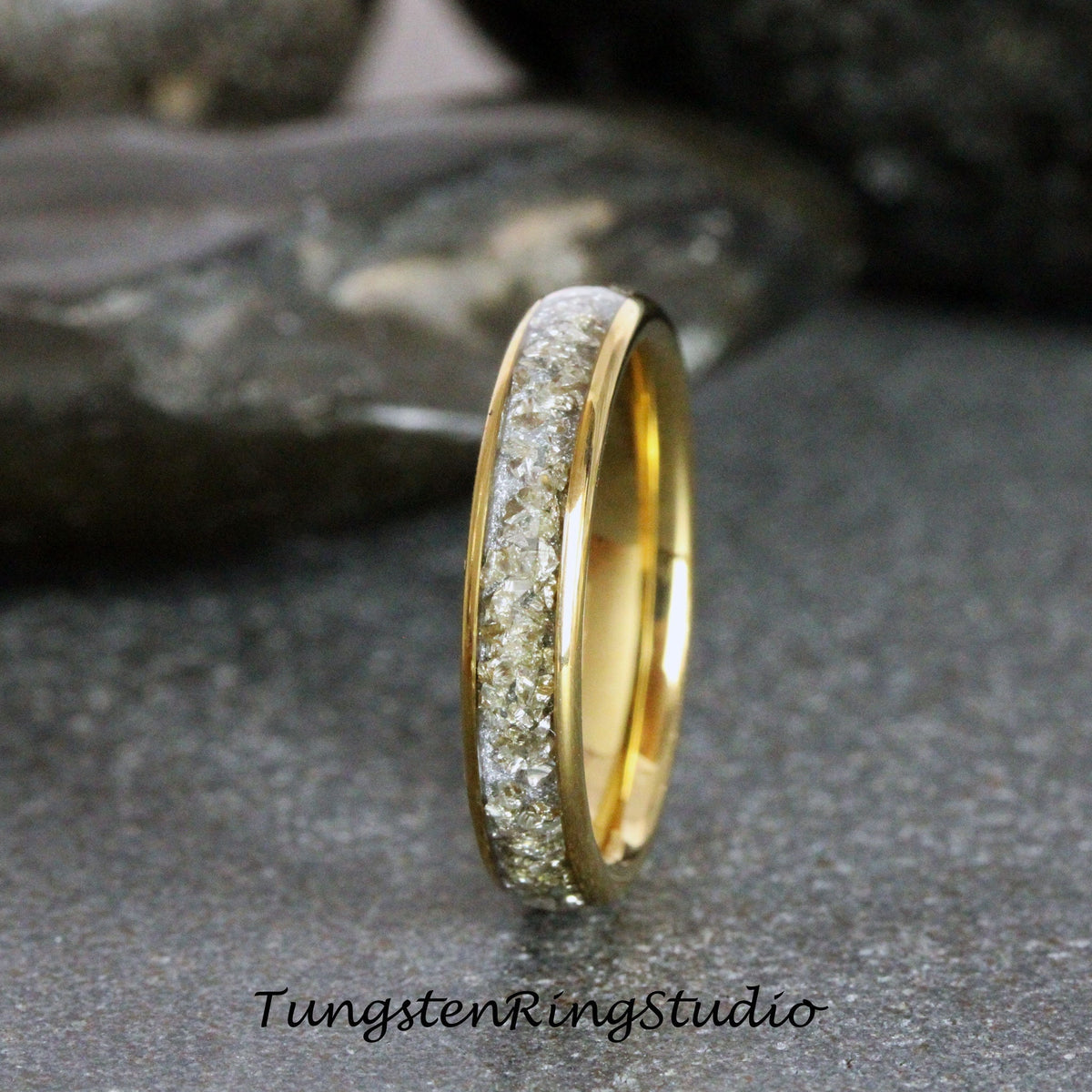 May include: A gold tungsten carbide ring with a band of small, clear diamonds.