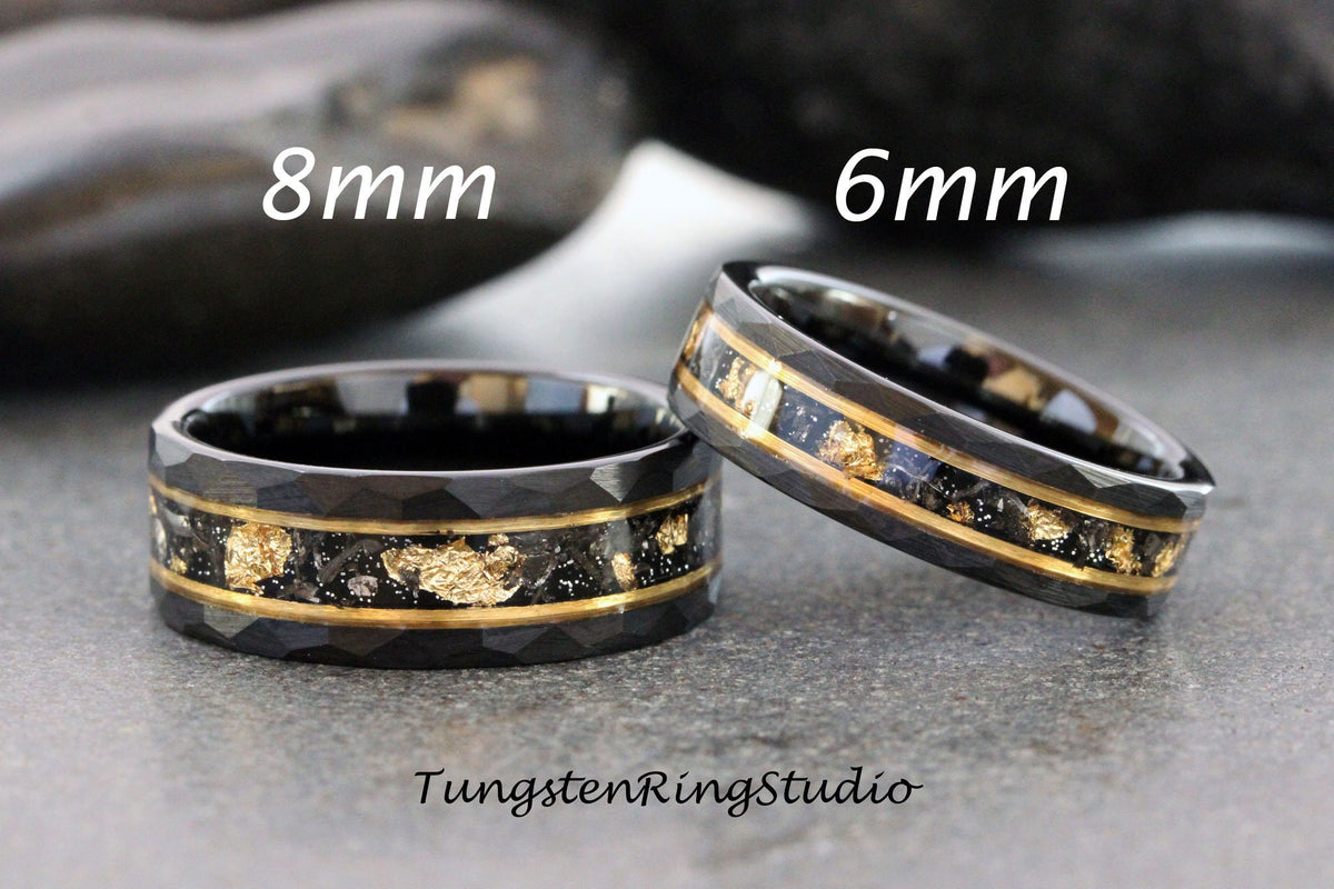 May include: Two tungsten carbide rings with a black finish and gold inlay. The ring on the left is 8mm wide and the ring on the right is 6mm wide.