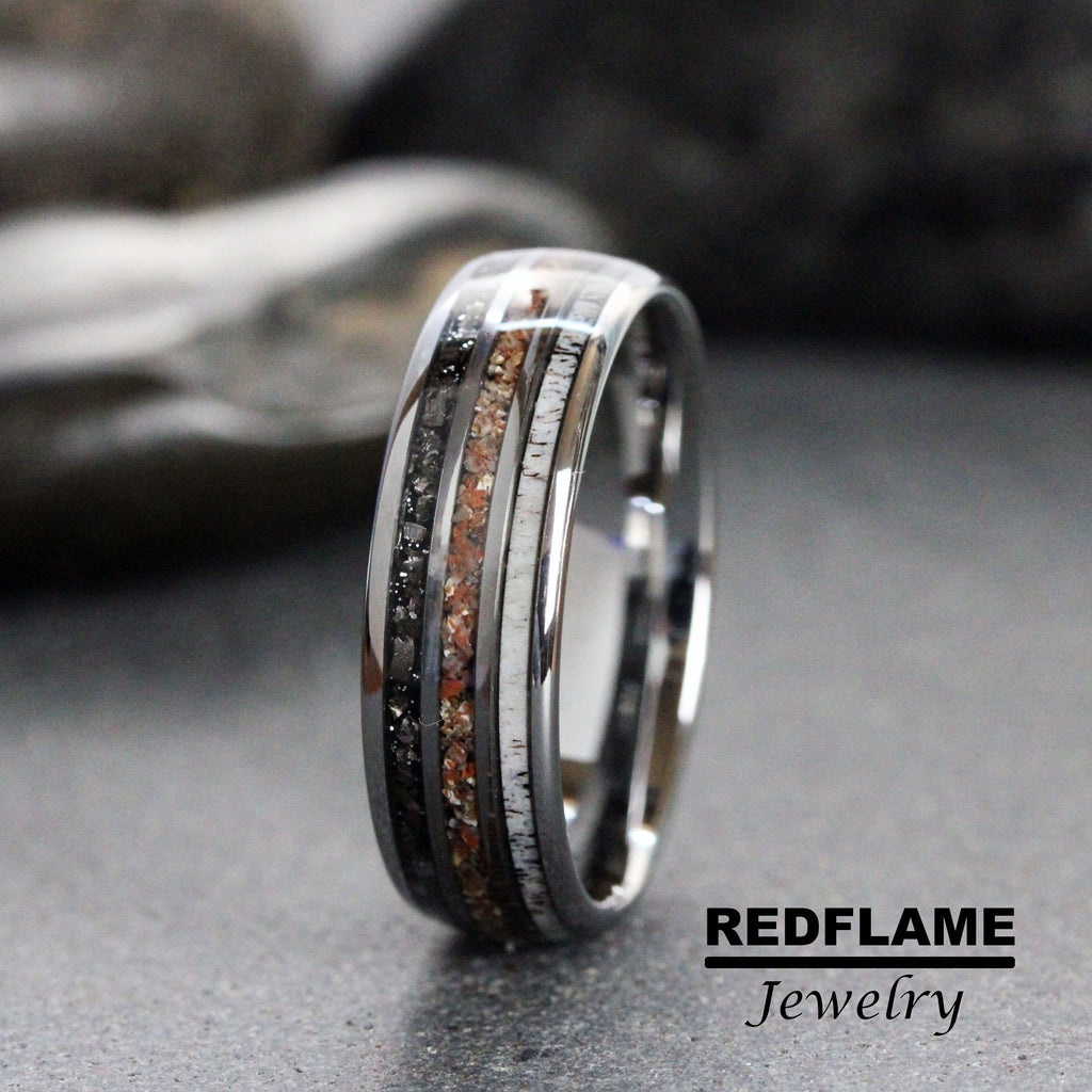 May include: A black tungsten carbide ring with a band of white and brown wood inlay and a band of black diamonds.