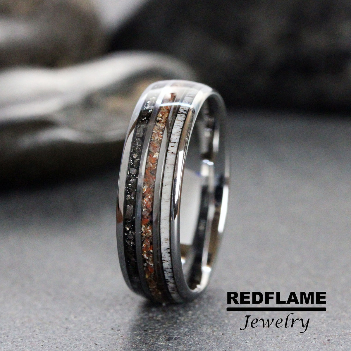 May include: A black tungsten carbide ring with a band of white and brown wood inlay and a band of black diamonds.