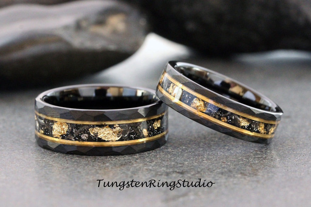 May include: Two black tungsten carbide rings with a gold inlay. The rings have a beveled edge and a textured surface. The gold inlay is made of real gold flakes.