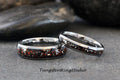 May include: Two silver tungsten carbide rings with a black and red inlay. The rings are stacked on top of each other. TungstenRingStudio.