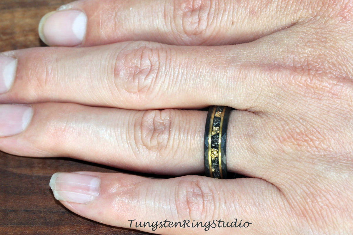 May include: A black tungsten ring with a gold inlay. The ring has a brushed finish and a beveled edge.