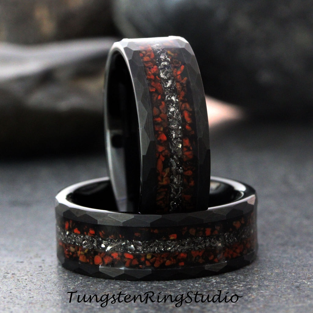 May include: Two black tungsten carbide rings with a red and silver inlay. The rings have a hammered finish.