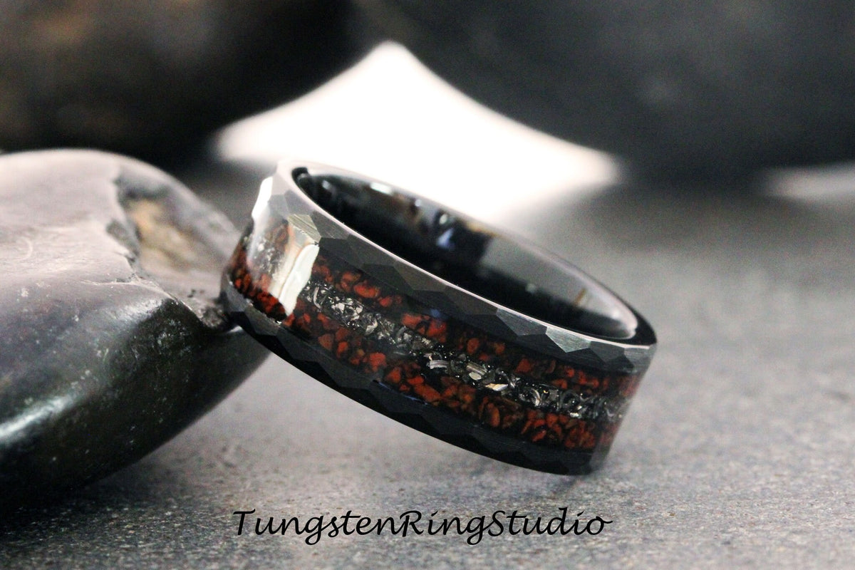 May include: Black tungsten carbide ring with a red and silver inlay. The ring has a brushed finish and a beveled edge.