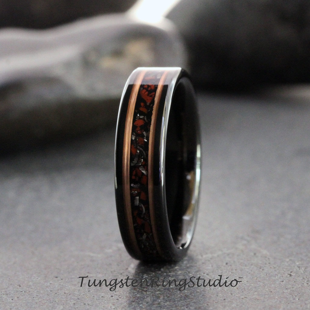 May include: A black tungsten carbide ring with a copper and red inlay. The inlay has a speckled pattern.