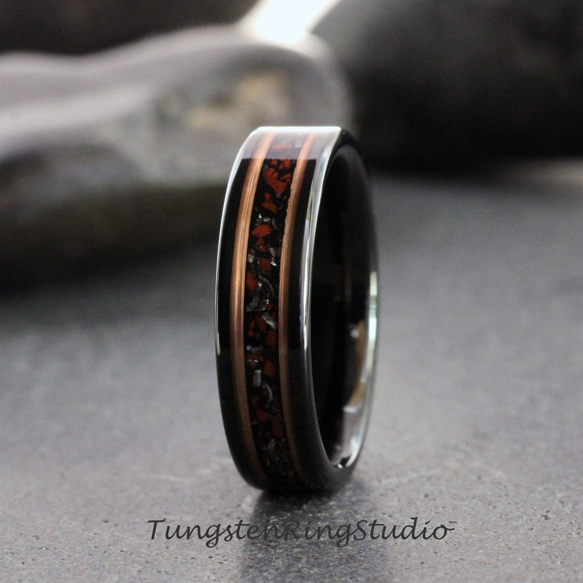 May include: A black tungsten carbide ring with a copper and red inlay. The inlay has a speckled pattern.