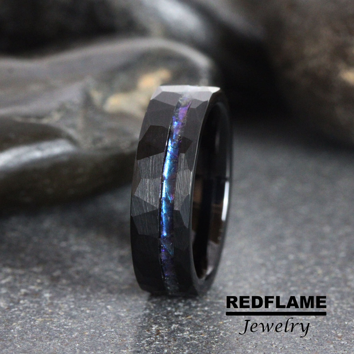 May include: Black tungsten carbide ring with a hammered finish and a blue iridescent inlay.  REDFLAME Jewelry.