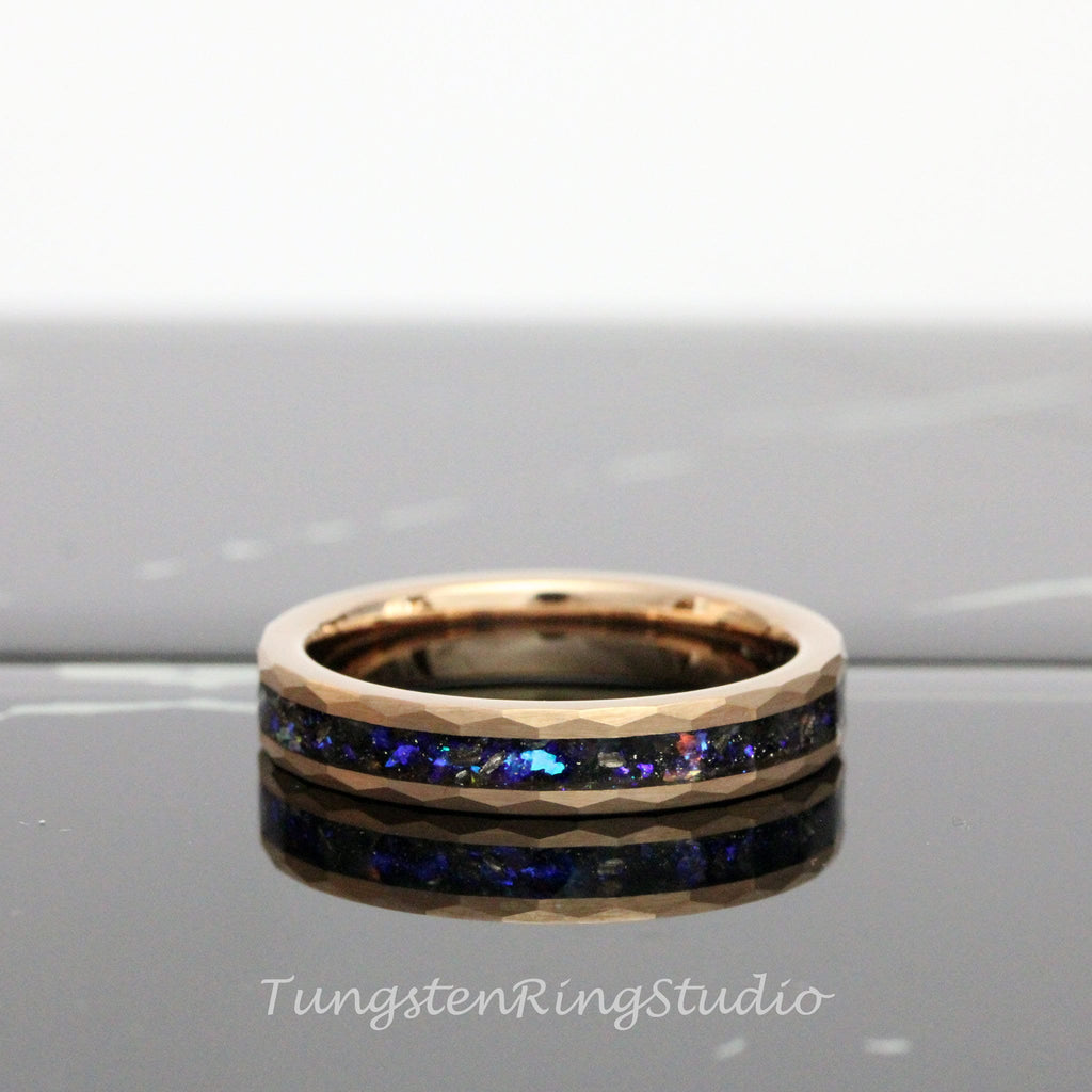 May include: A rose gold tungsten carbide ring with a black and blue inlay. The ring has a beveled edge and a polished finish.