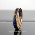May include: A rose gold tungsten carbide ring with a blue and black inlay. The ring has a hammered finish.