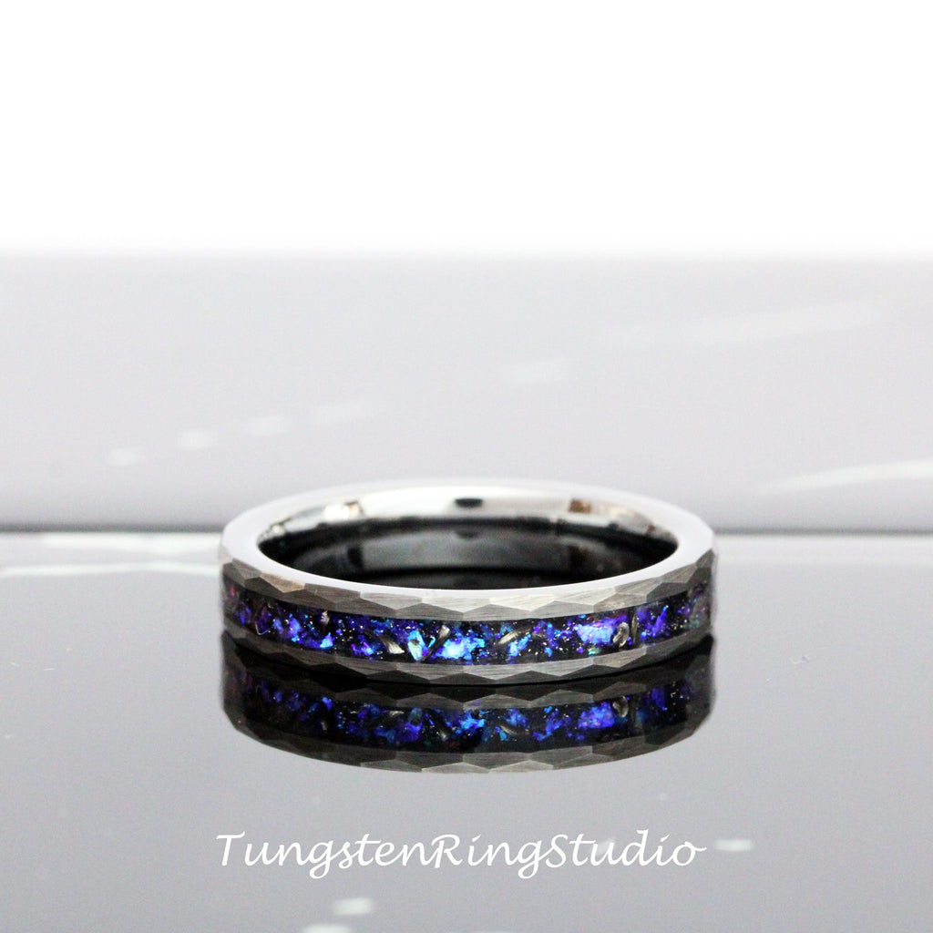 May include: A silver tungsten ring with a blue and black inlay. The ring has a hammered finish and a beveled edge.