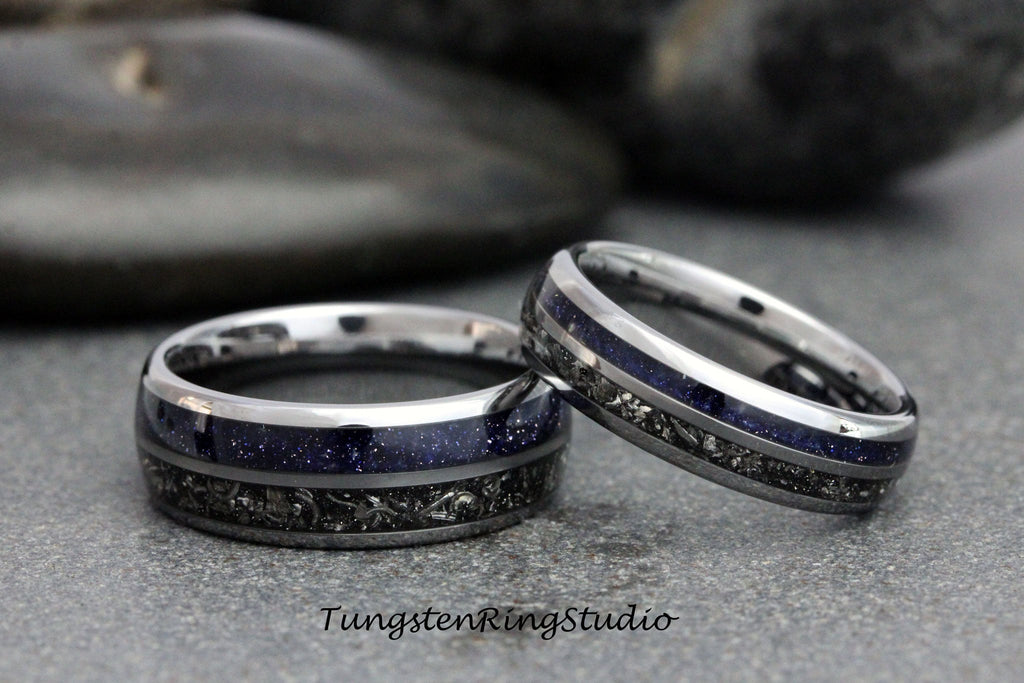 May include: Two matching rings with a silver band, a dark blue center, and a dark gray patterned inlay. The rings are set against a gray background. The text "TungstenRingStudio" is visible at the bottom.