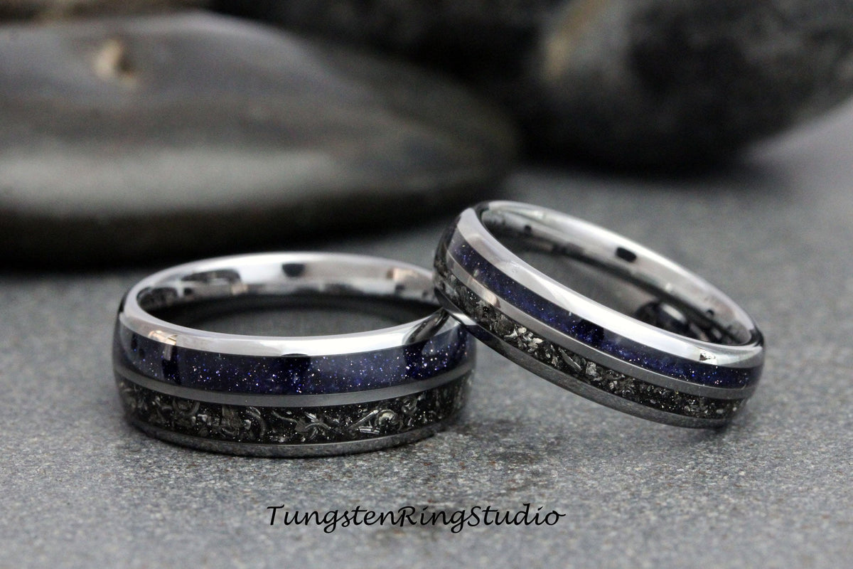 May include: Two matching rings with a silver band, a dark blue center, and a dark gray patterned inlay. The rings are set against a gray background. The text "TungstenRingStudio" is visible at the bottom.