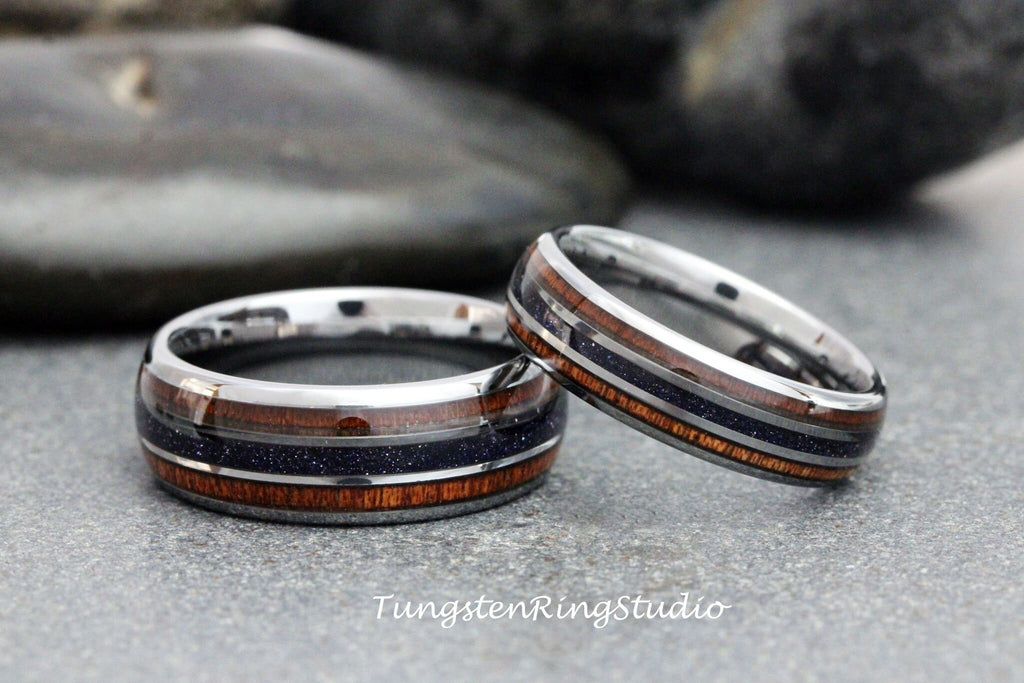 May include: Two silver tungsten carbide rings with a black and brown inlay. The rings are stacked on top of each other.