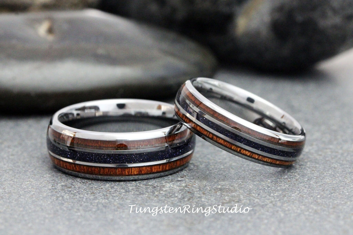May include: Two silver tungsten carbide rings with a black and brown inlay. The rings are stacked on top of each other.