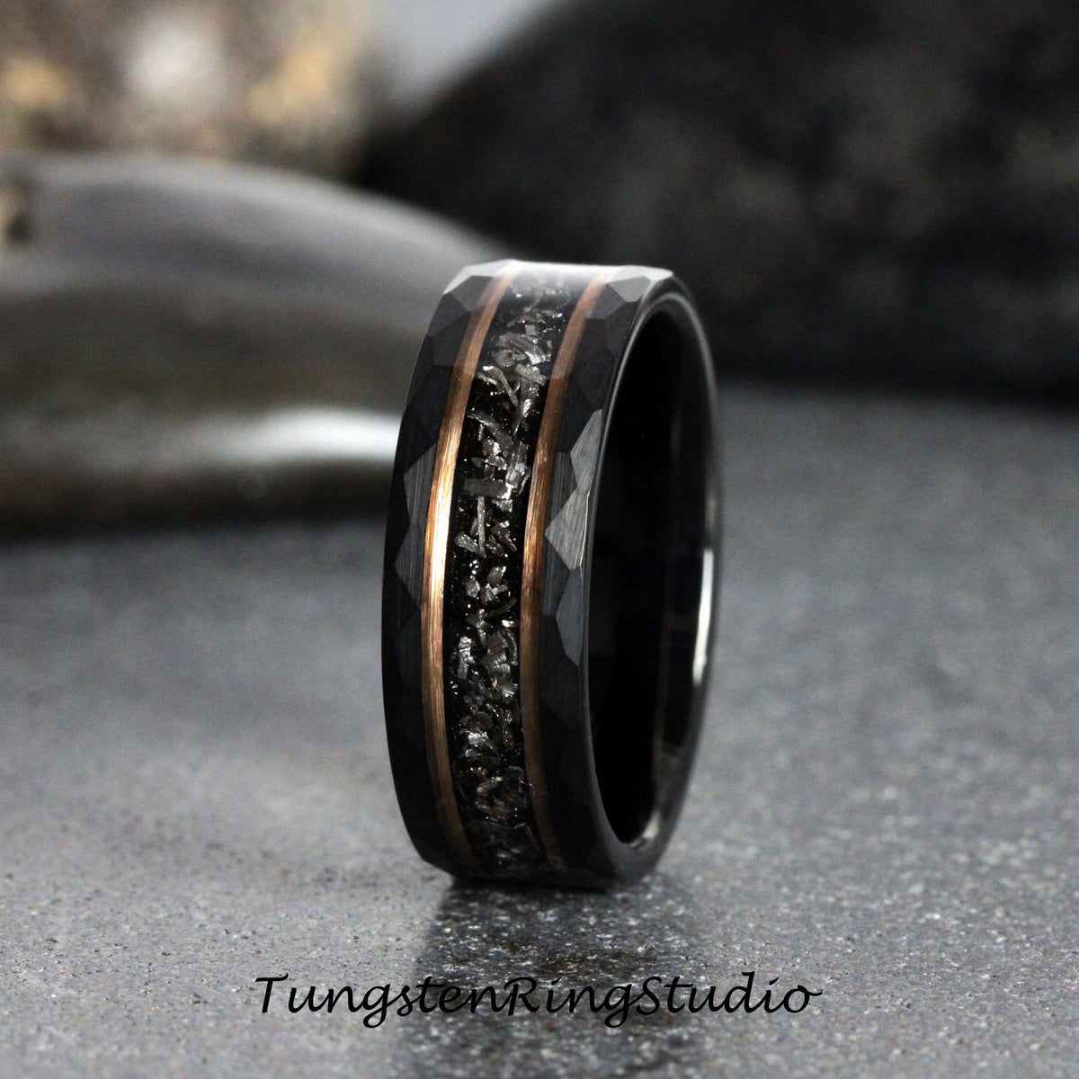 May include: A black tungsten carbide ring with a hammered finish and a copper inlay. The inlay features a black meteorite pattern.