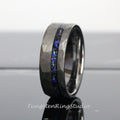May include: A black tungsten carbide ring with a hammered finish and a blue and black inlay. The ring is a popular choice for men's wedding bands.