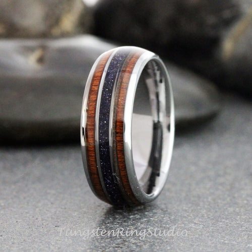 May include: A silver tungsten ring with a brown wood inlay and a thin band of purple glitter.