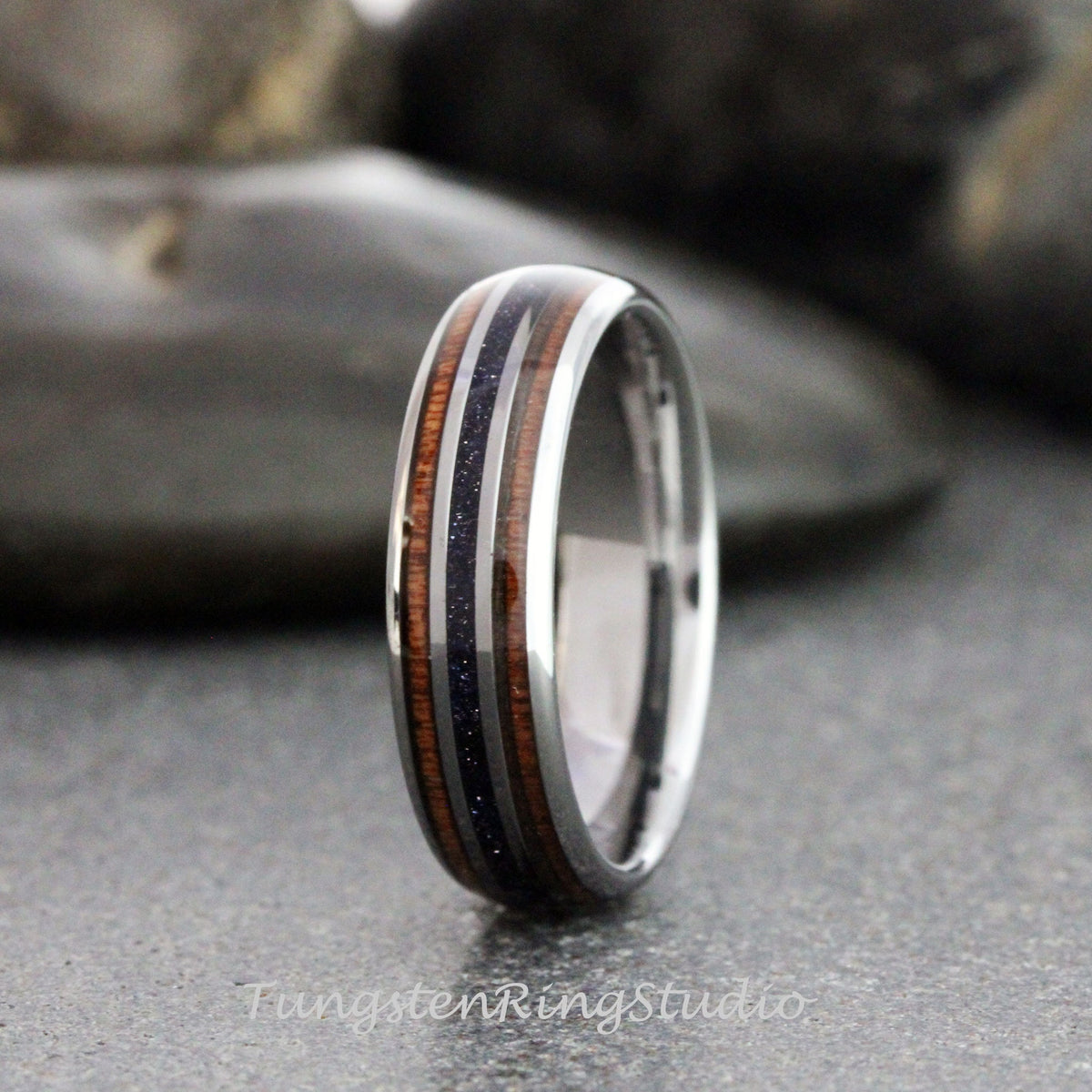 May include: A silver tungsten ring with two brown wood inlays and a black inlay with silver glitter.