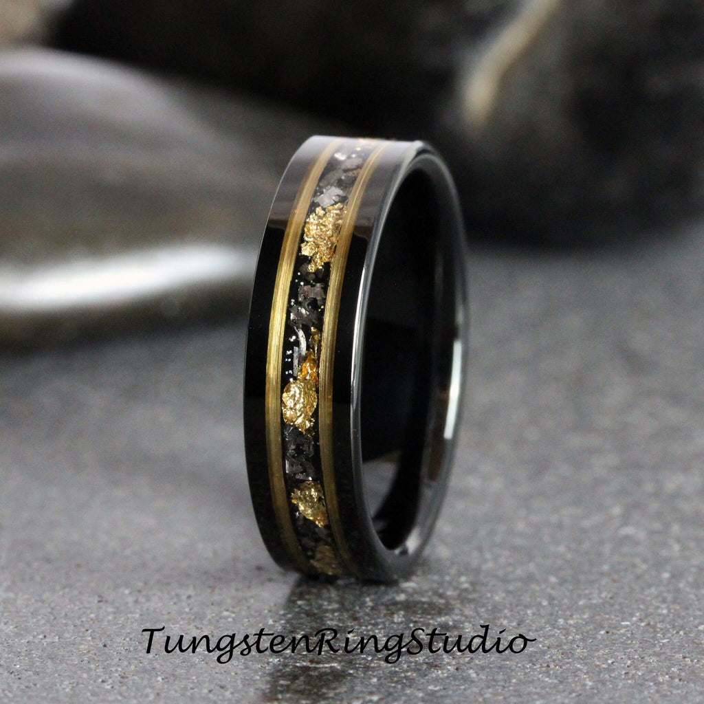 May include: Black tungsten carbide ring with a gold inlay and black diamond accents. The ring has a polished finish.