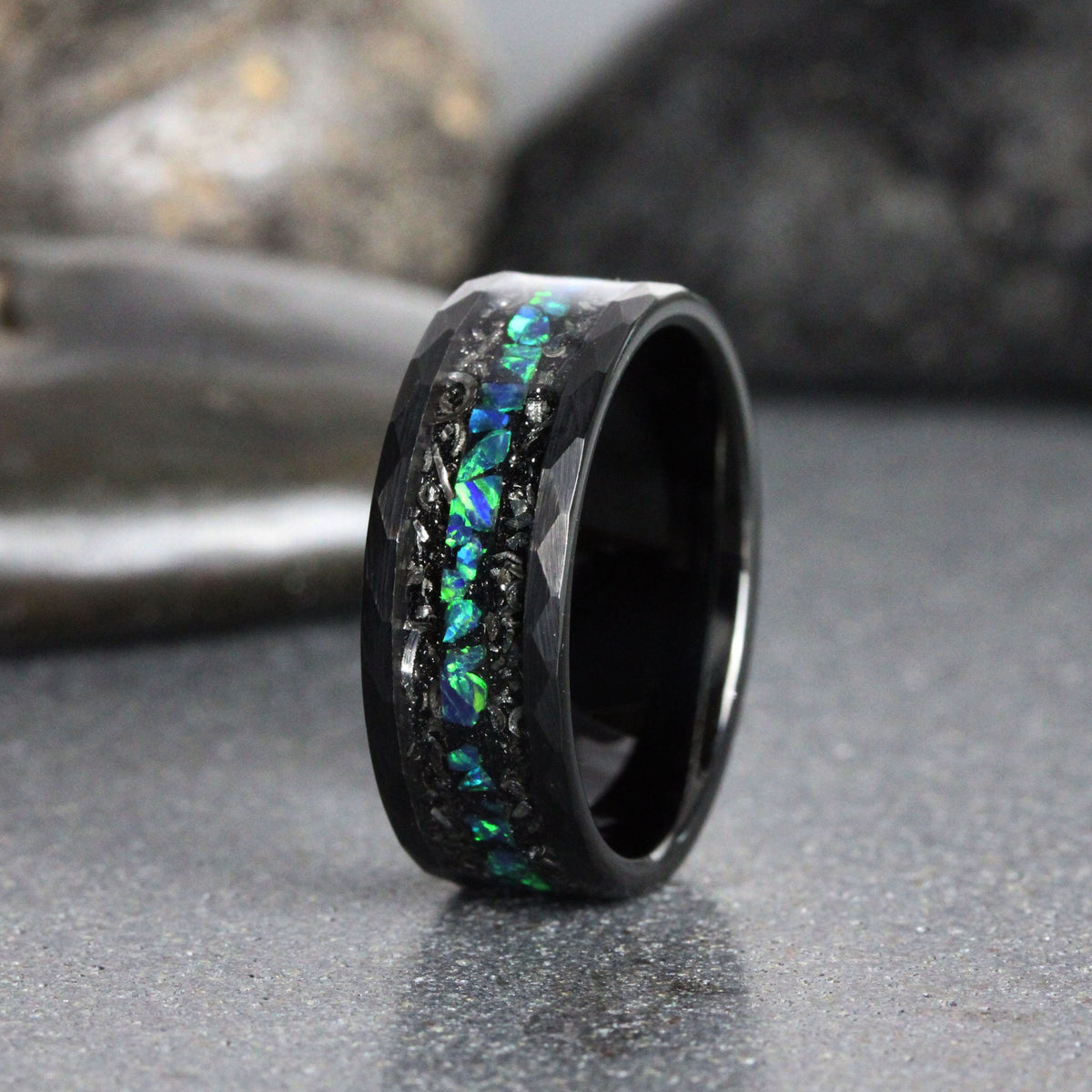 May include: A black tungsten carbide ring with a hammered finish and a band of green and blue opal inlay.