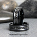 May include: Two black tungsten carbide rings with a silver inlay design. The rings are stacked on top of each other.
