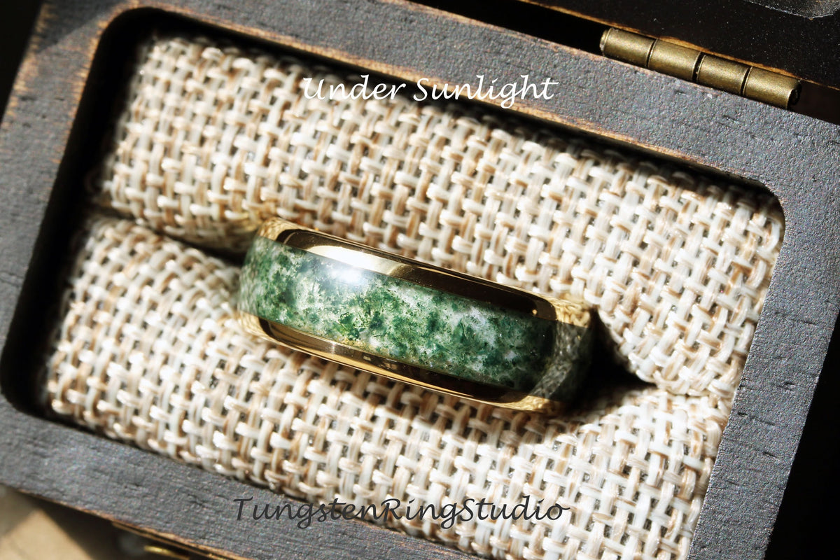 May include: A gold tungsten ring with a green and white agate inlay. The ring is in a small wooden box with a brown fabric lining. The text "Under Sunlight" is printed on the box.