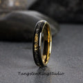 May include: A black tungsten carbide ring with a gold inlay. The ring has a polished finish and a comfortable fit.