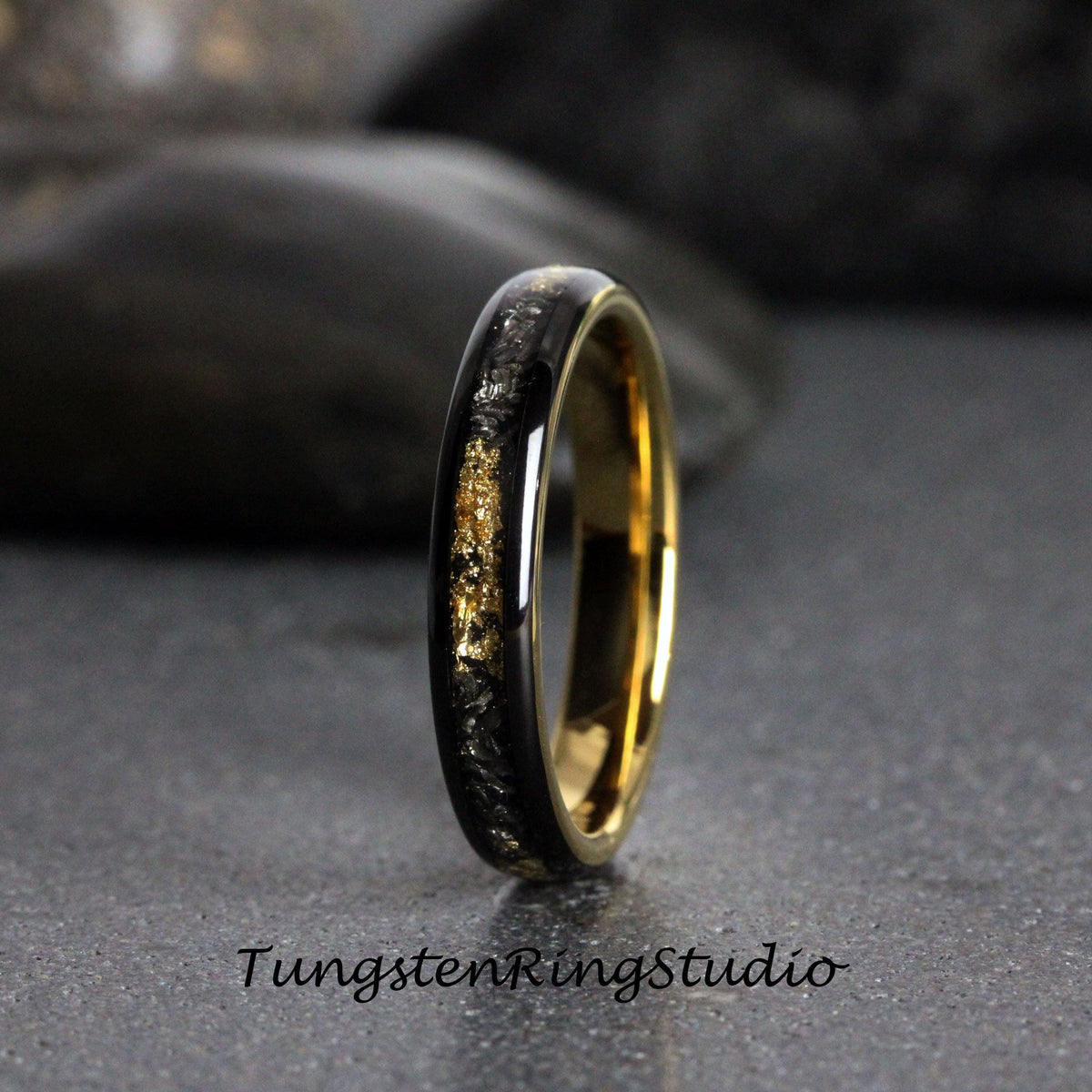 May include: A black tungsten carbide ring with a gold inlay. The ring has a polished finish and a comfortable fit.