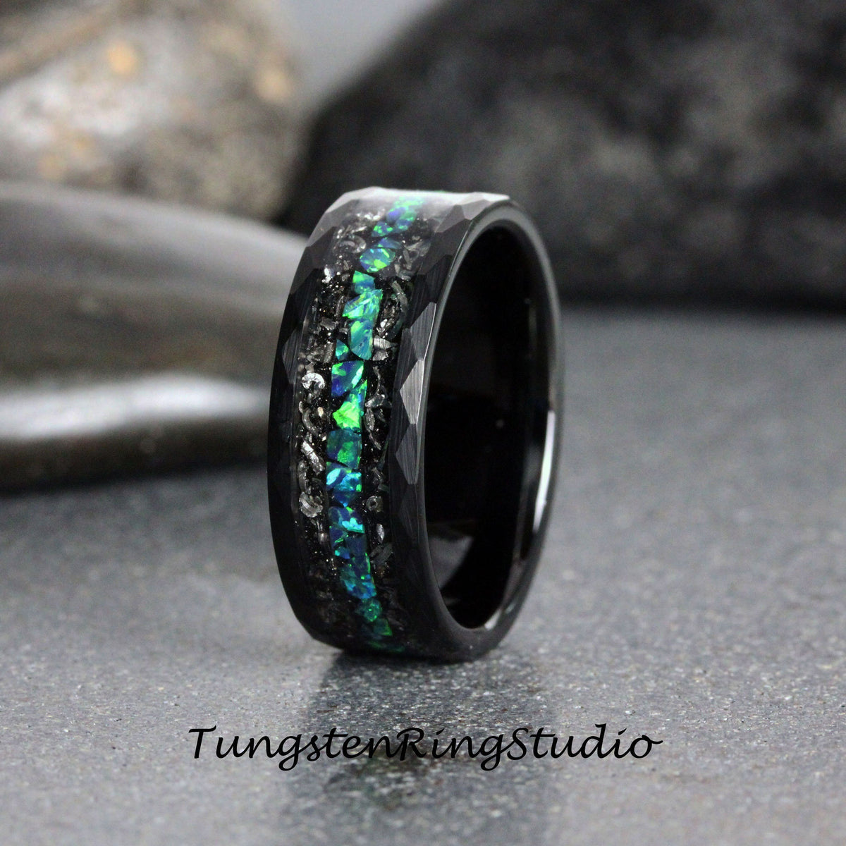May include: Black tungsten carbide ring with a hammered finish and a band of green and blue opal inlay.