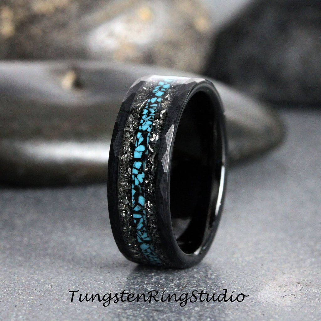 May include: A black tungsten carbide ring with a blue and silver inlay. The ring has a hammered finish.