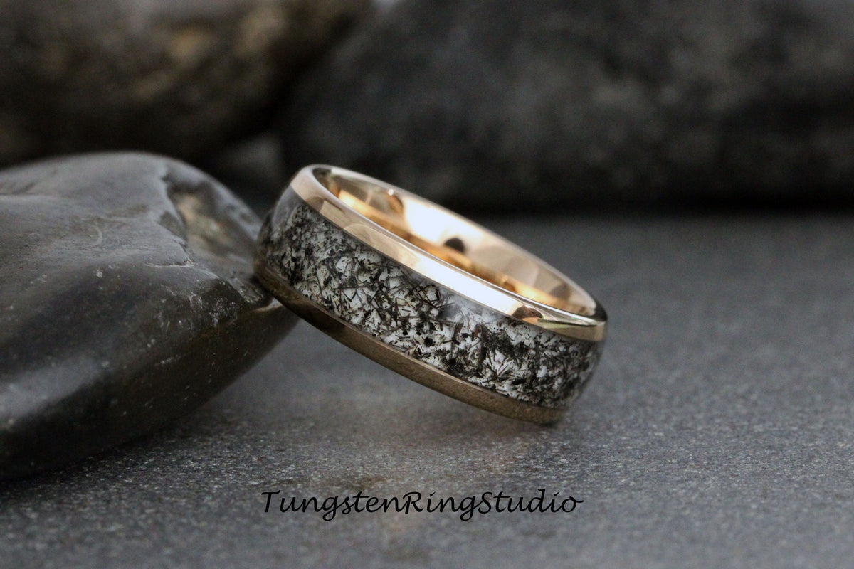 May include: A black and white tungsten ring with a gold band. The ring has a unique, speckled pattern.