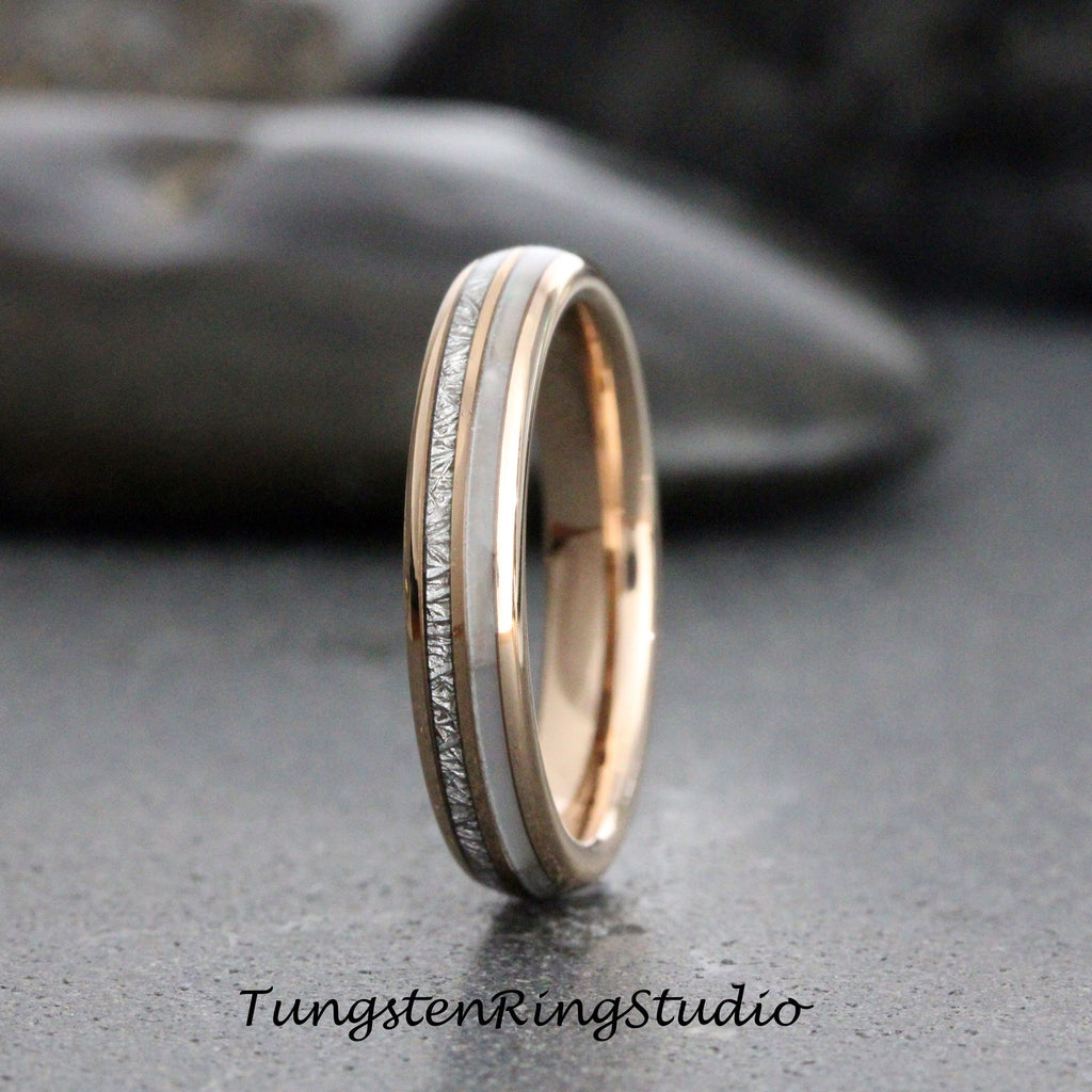 May include: A thin silver and rose gold tungsten ring with a white inlay and a textured silver band.