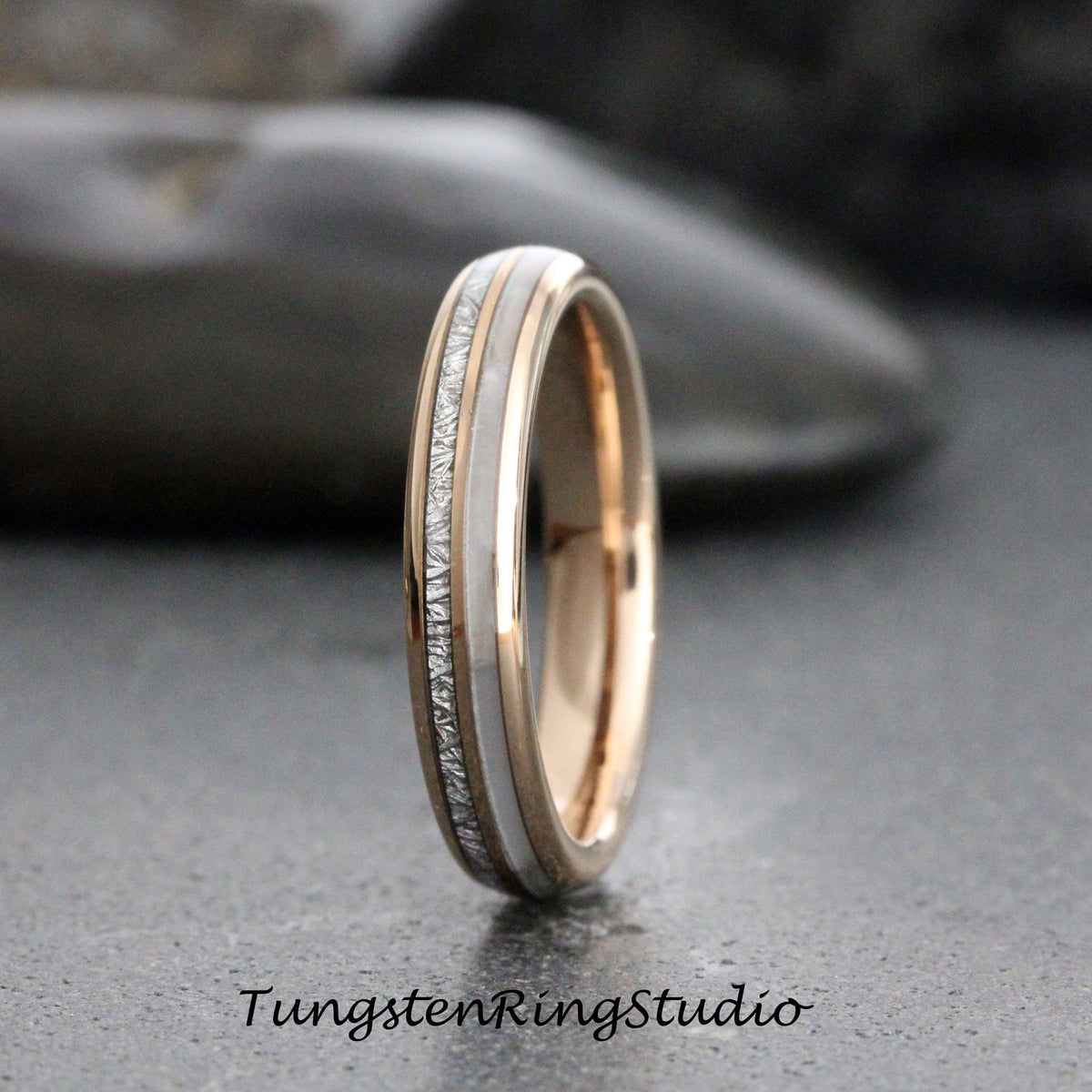 May include: A thin silver and rose gold tungsten ring with a white inlay and a textured silver band.