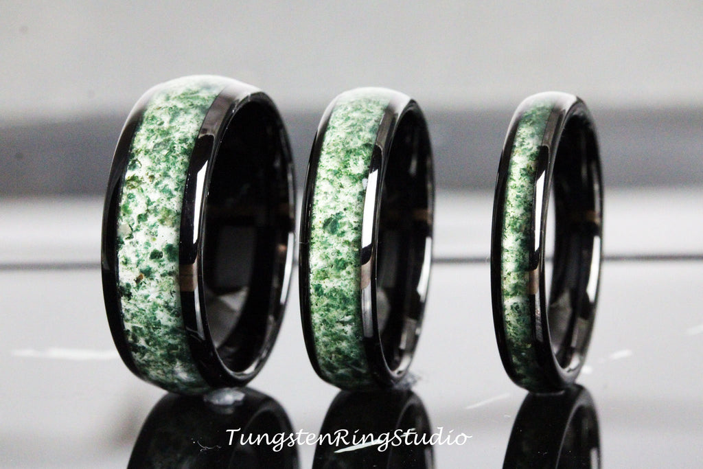 May include: Three black tungsten carbide rings with a green inlay. The rings are different sizes.