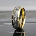 May include: A gold-colored ring with a band of white and black speckled material. The ring has a polished finish and a smooth, rounded shape. The text "TungstenRingStudio" is visible at the bottom of the image.