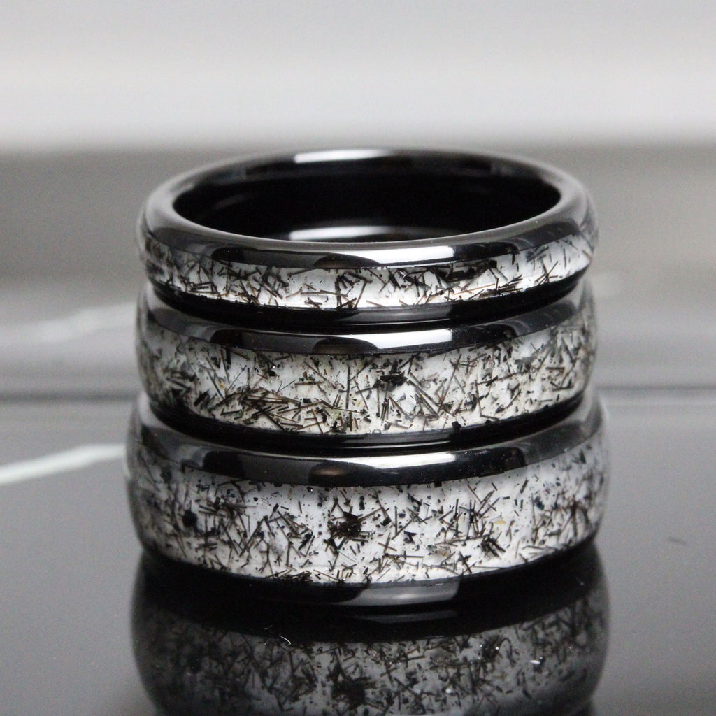 May include: Three black ceramic rings with a white speckled pattern. The rings are stacked on top of each other.