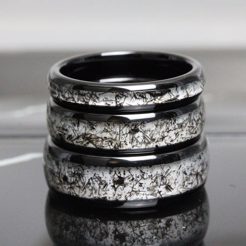 May include: Three black ceramic rings with a white speckled pattern. The rings are stacked on top of each other.