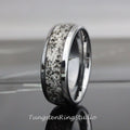 May include: A silver tungsten carbide ring with a black and white inlay. The inlay has a unique pattern of small black flecks on a white background.