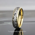 May include: A tungsten carbide ring with a black and white speckled inlay and a gold band.