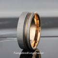 May include: A silver tungsten ring with a rose gold inlay and a brushed finish. The ring has a grooved design around the inlay.