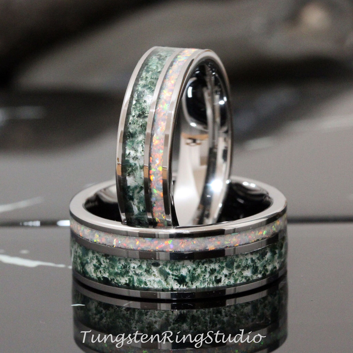 May include: Two tungsten carbide rings with a green and white inlay. The rings are stacked on top of each other. The inlay is made of a green stone and white opal.