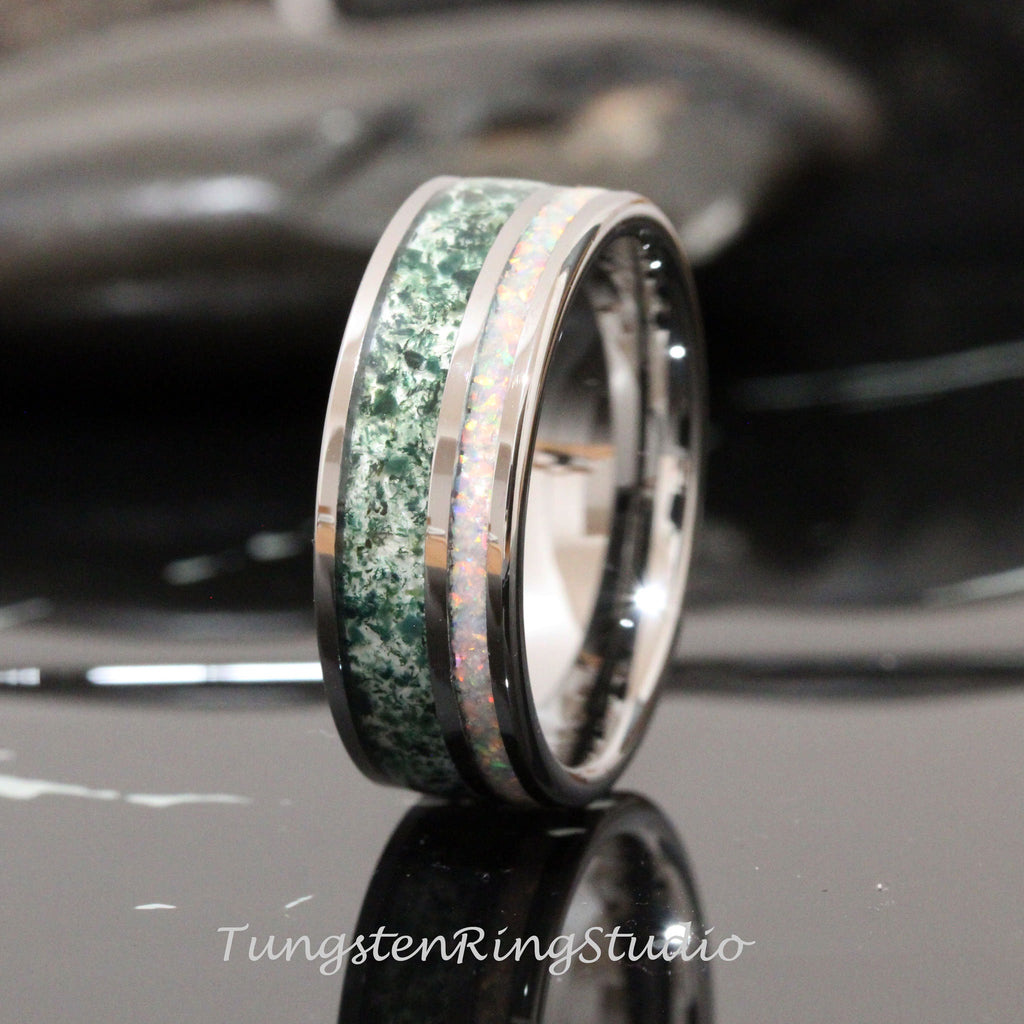 May include: A silver tungsten ring with a green and white inlay. The inlay is a green stone with white flecks and a white opal.