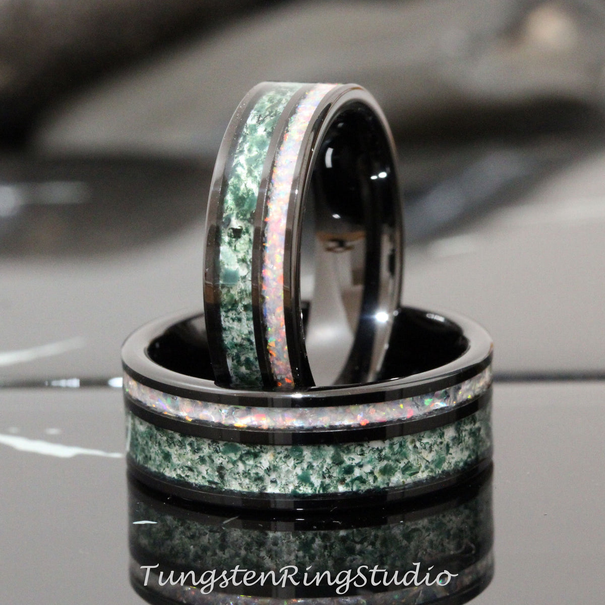 May include: Two black tungsten carbide rings with green and white inlay. The rings are stacked on top of each other.