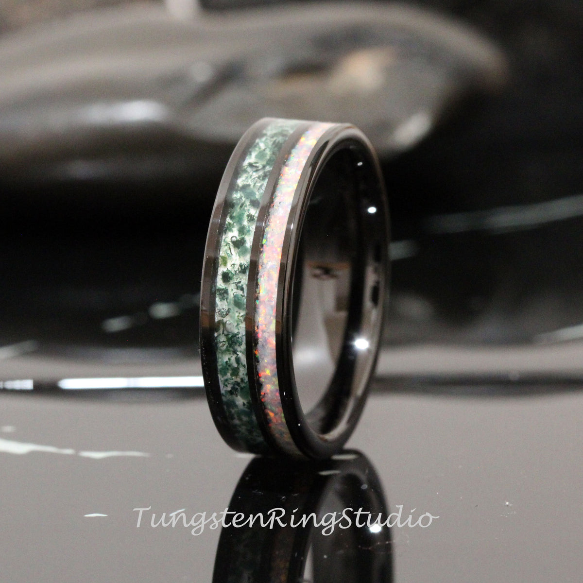 May include: Black tungsten carbide ring with a green and white inlay. The inlay is made of opal and green stone.