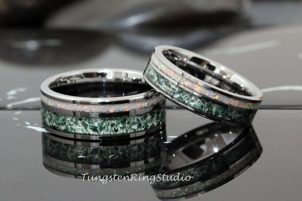 May include: Two silver tungsten carbide rings with green and white opal inlay. The rings are stacked on top of each other.